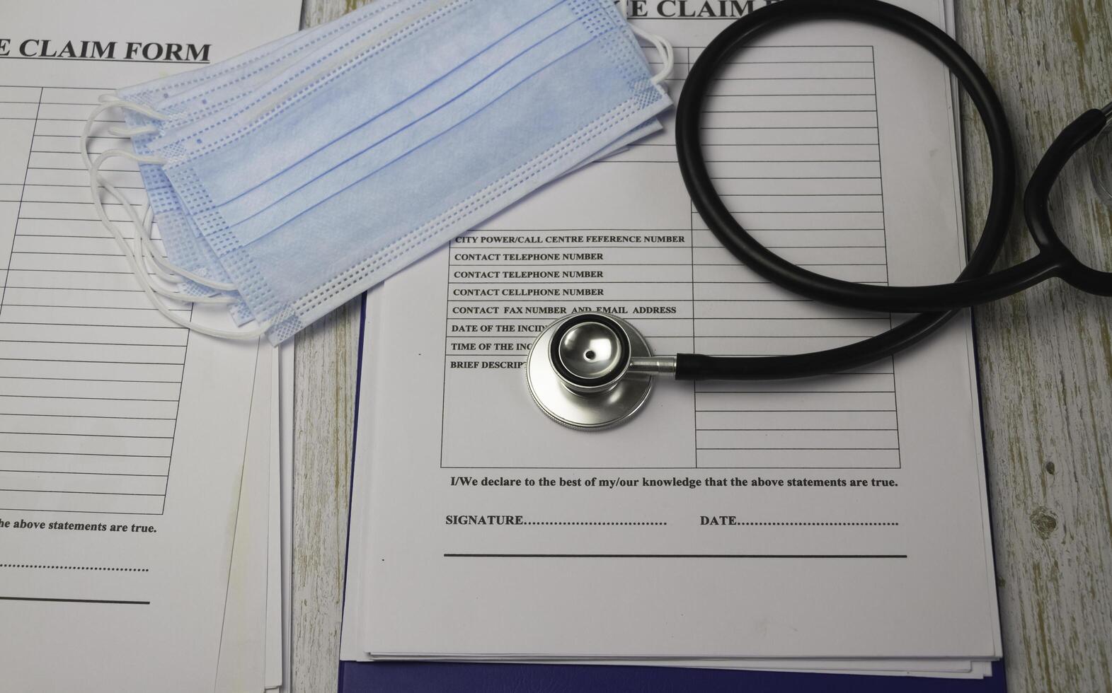 Stethoscope and Medical Mask put on Insurance claim form photo