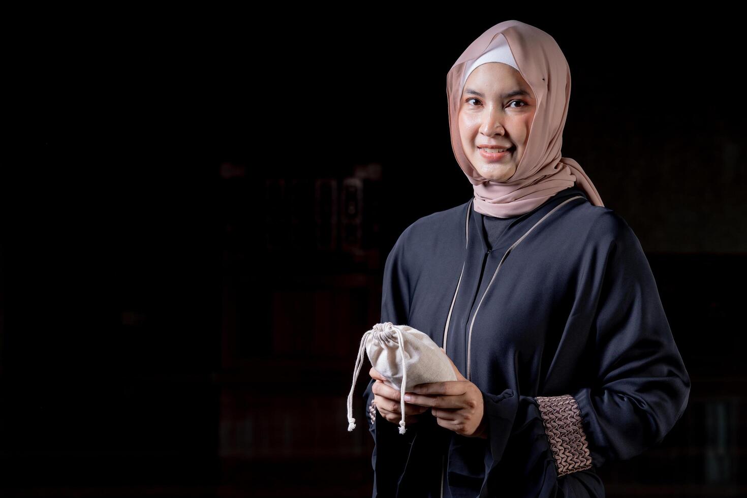 Hands holding a money bag for zakat, Islamic zakat concept. Muslims help the poor and needy. Conceptual shoot for property, income, and fitrah zakat. photo