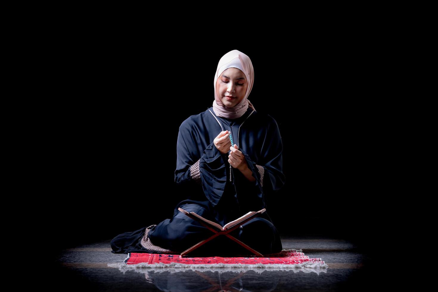 The image of an Asian Muslim woman in the Islamic religion in hijab in cream color. reading the Quran and having a happy smiling face Staying in a beautiful mosque out of respect for God. photo