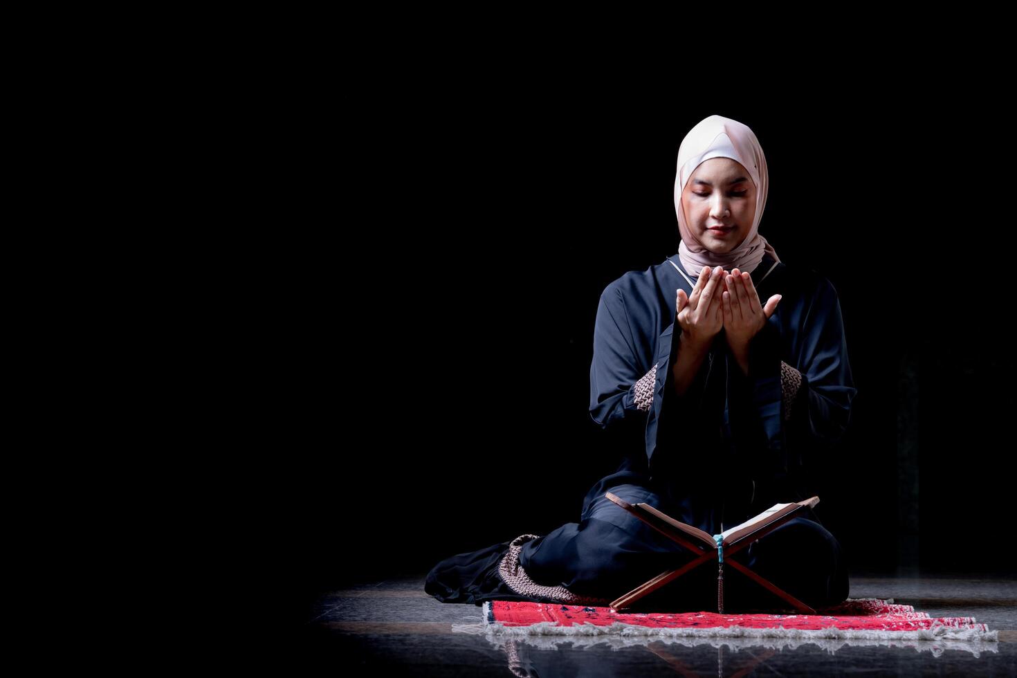 The image of an Asian Muslim woman in the Islamic religion in hijab in cream color. reading the Quran and having a happy smiling face Staying in a beautiful mosque out of respect for God. photo