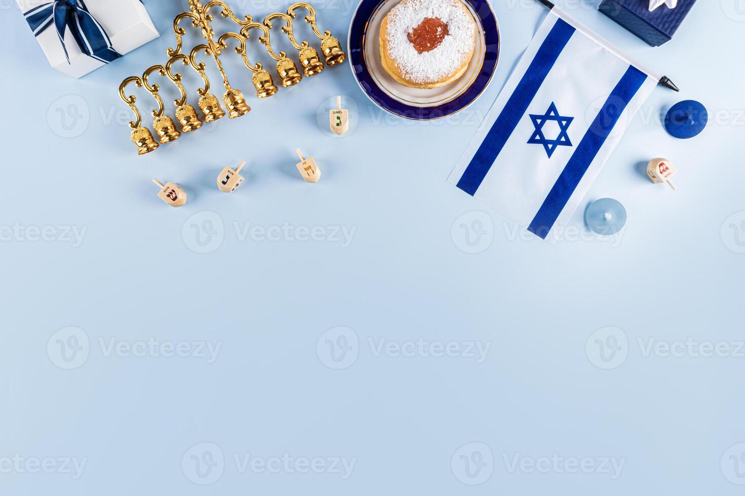 Traditional treats and symbols of the Jewish holiday of Hanukkah in blue white color on a blue background. top view. top border. space for your text. photo