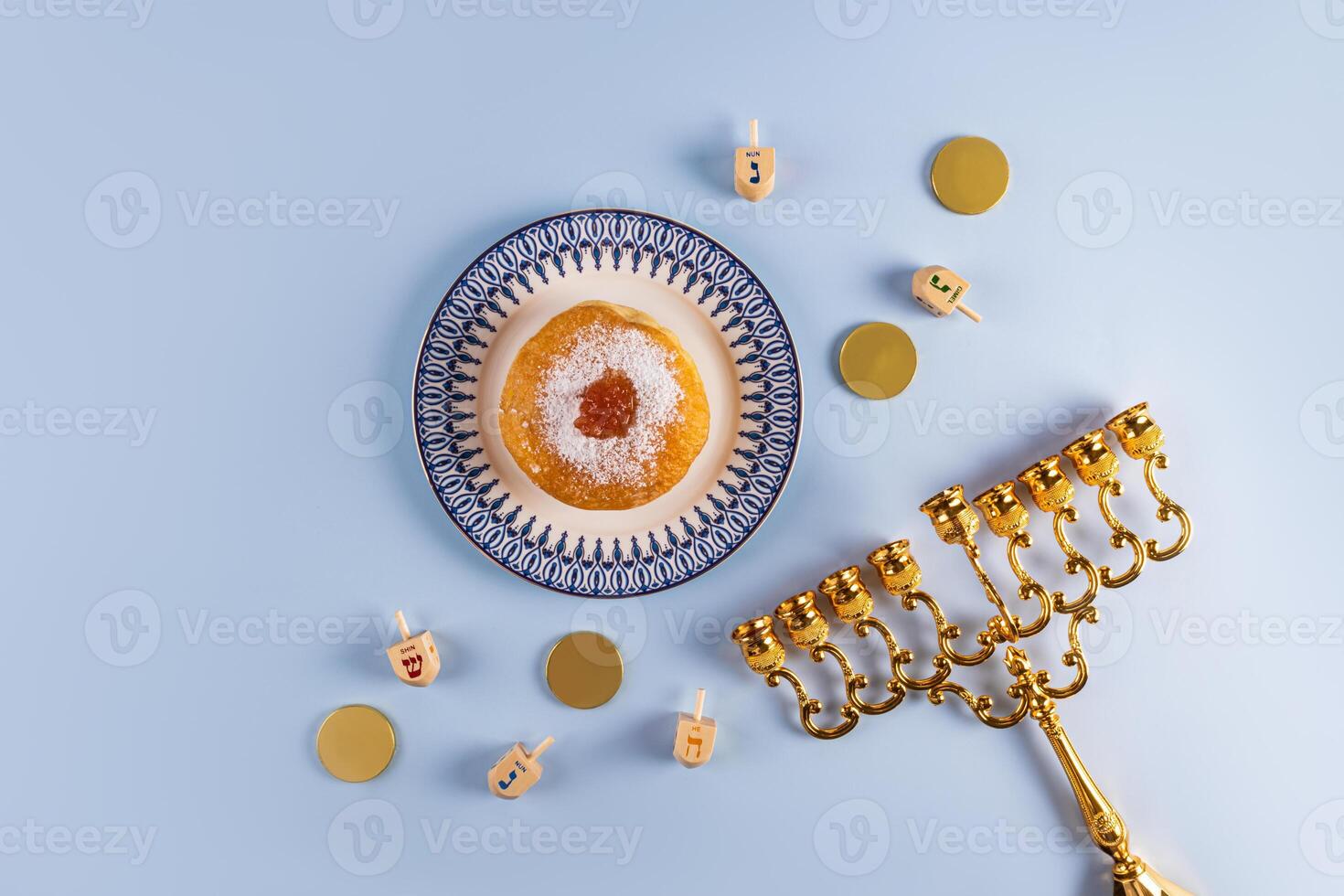 The concept of the Jewish holiday of Hanukkah. traditional treats, symbols of the holiday. Gold minor, donut, dreidels, coins. top view. A copy space. photo