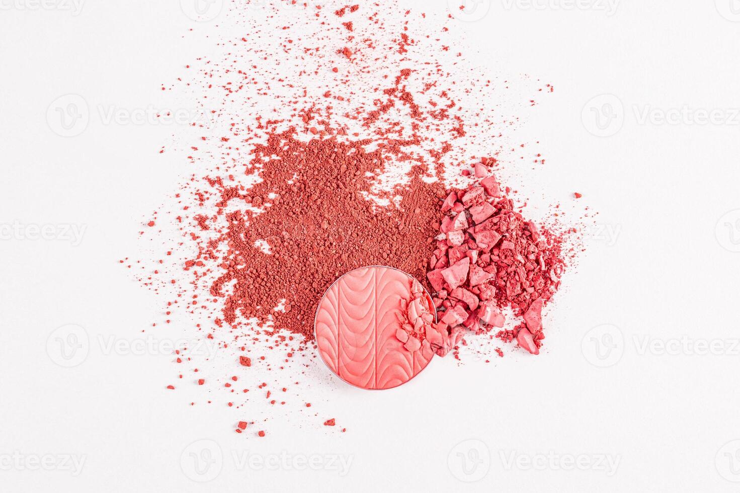 round block, refill blush with a relief pattern of pink tone and a scattering of dry blush on a white background. texture, a sample of blush. top view photo