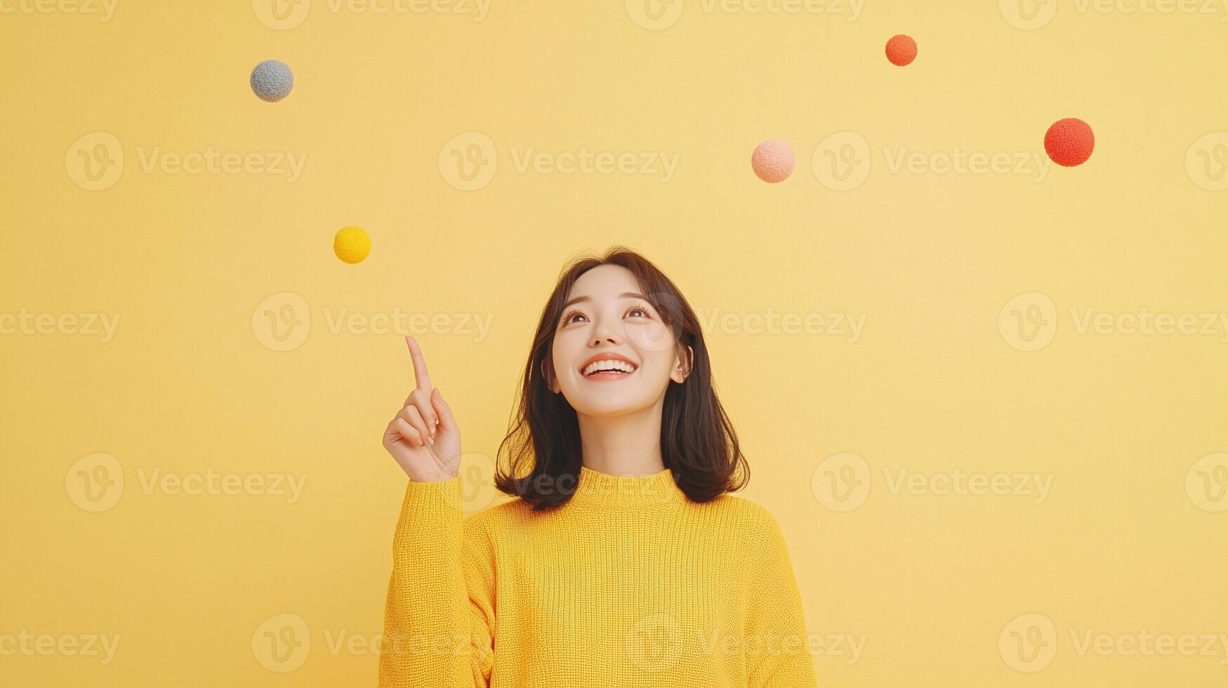 A woman in a yellow sweater is holding up a ball photo