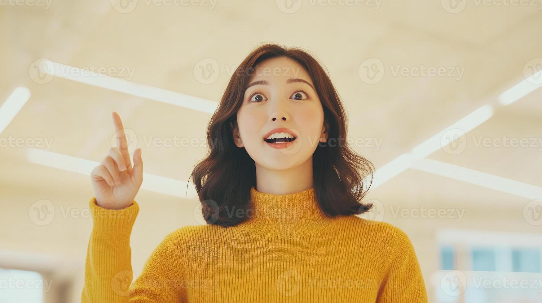 A woman in a yellow sweater pointing up photo