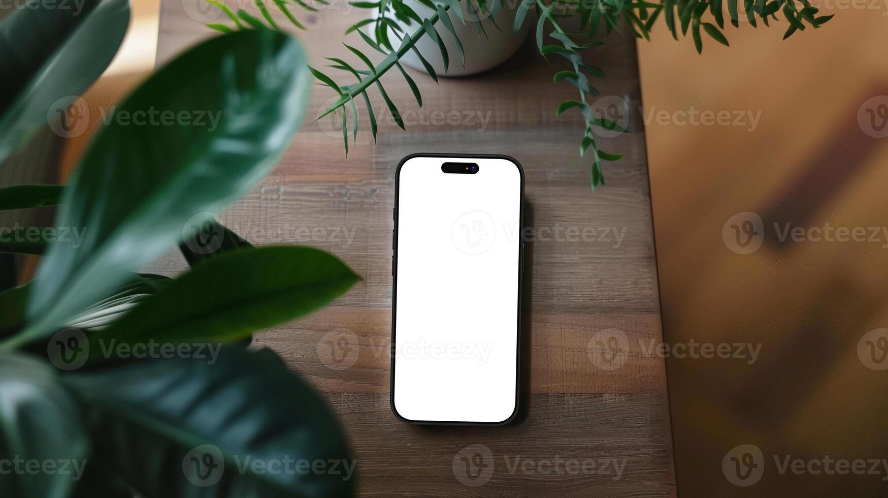 Black titanium smartphone mockup template with blank screen on wooden table with plants photo