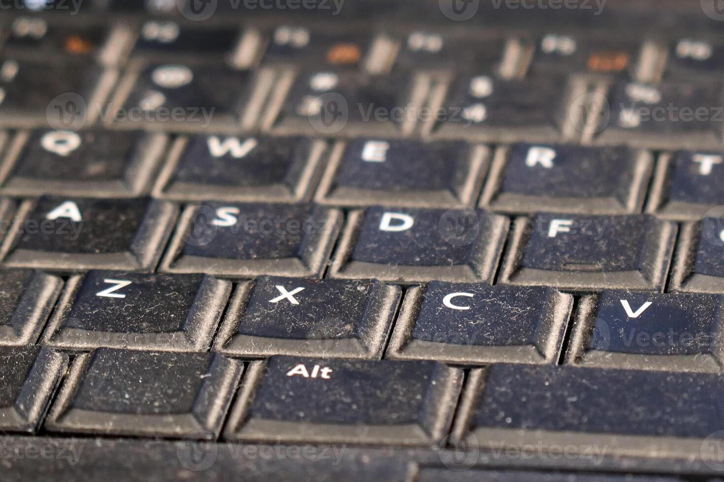 Dusty keyboard on a used laptop showing wear and tear during everyday tasks photo