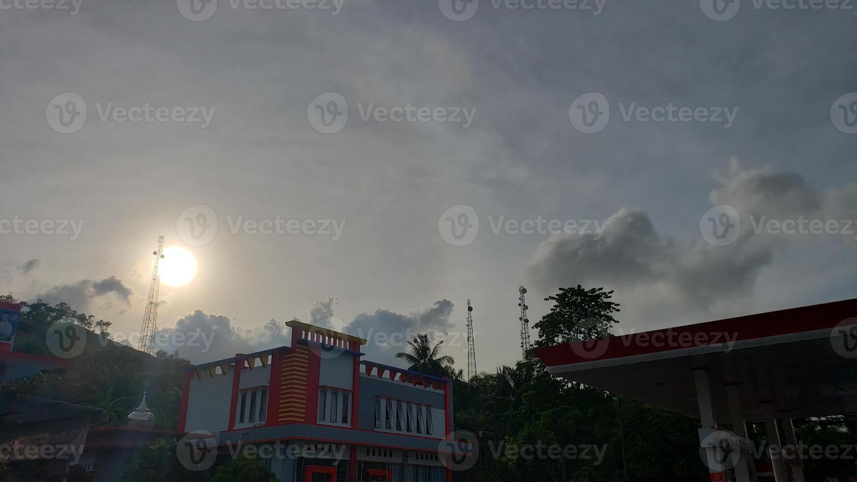 The sun is shining brightly over a gas station photo
