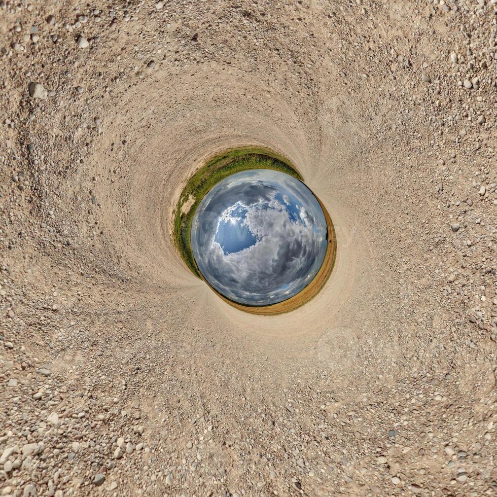 blue hole sphere or globe little planet inside green dry grass or stone with sand frame background photo
