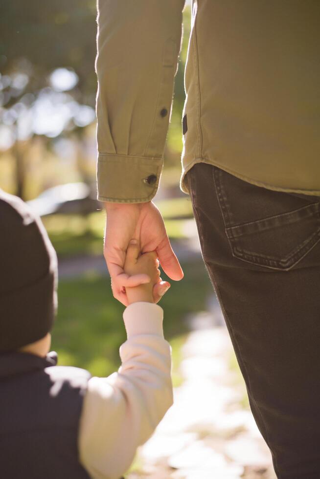 A man holding the hand of a small child photo