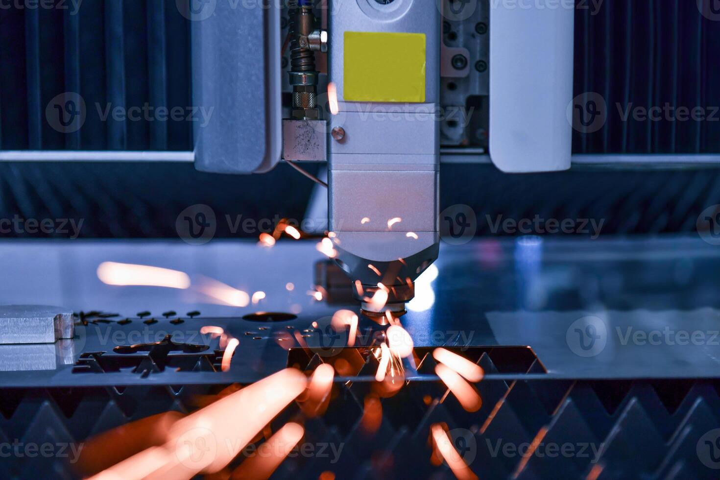 Industrial laser cut machine while cutting the sheet metal with the sparking light. photo