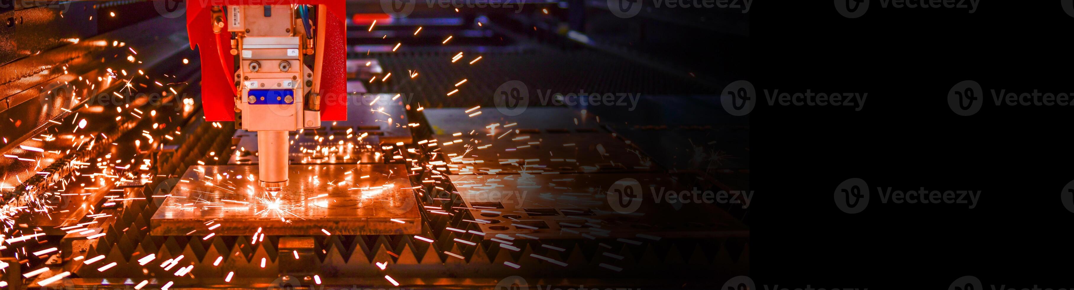Industrial laser cut machine while cutting the sheet metal with the sparking light.copy space photo
