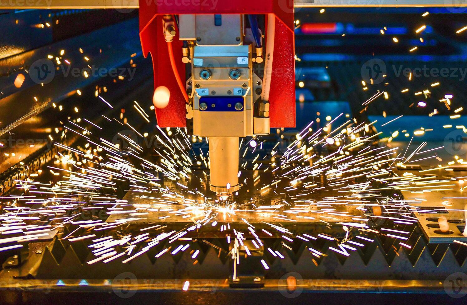 Industrial laser cut machine while cutting the sheet metal with the sparking light. photo