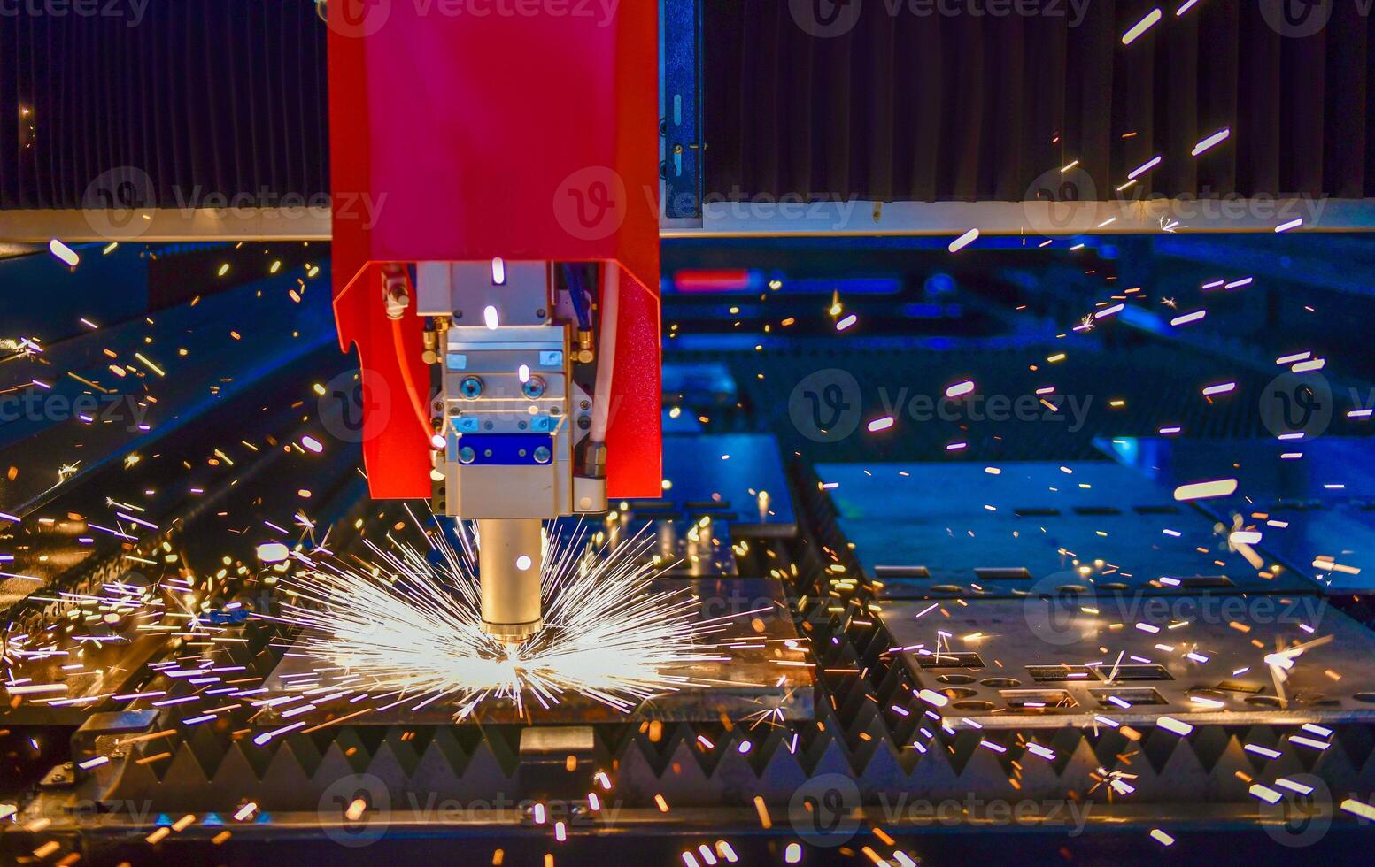 Industrial laser cut machine while cutting the sheet metal with the sparking light. photo