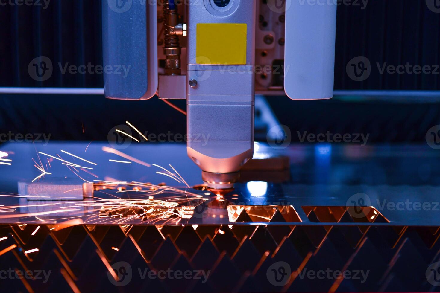 Industrial laser cut machine while cutting the sheet metal with the sparking light. photo