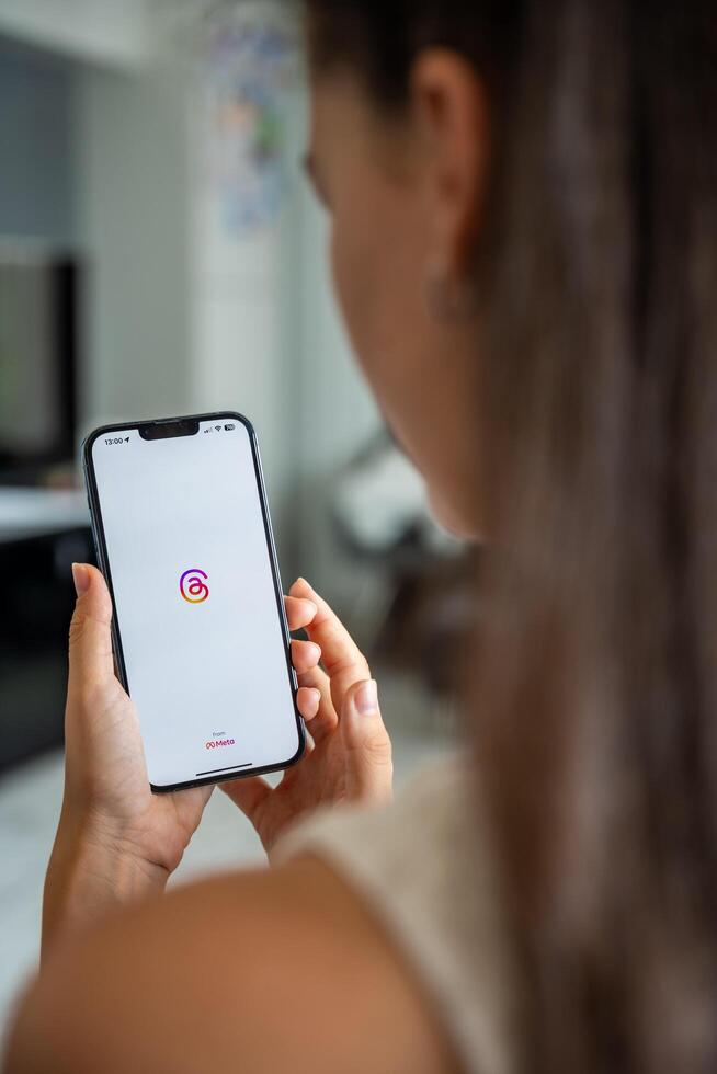 Prague, Czech republic - May 2, 2024. Woman holding iPhone with logo of application Instagram on the screen, using mobile application for business home. High quality photo