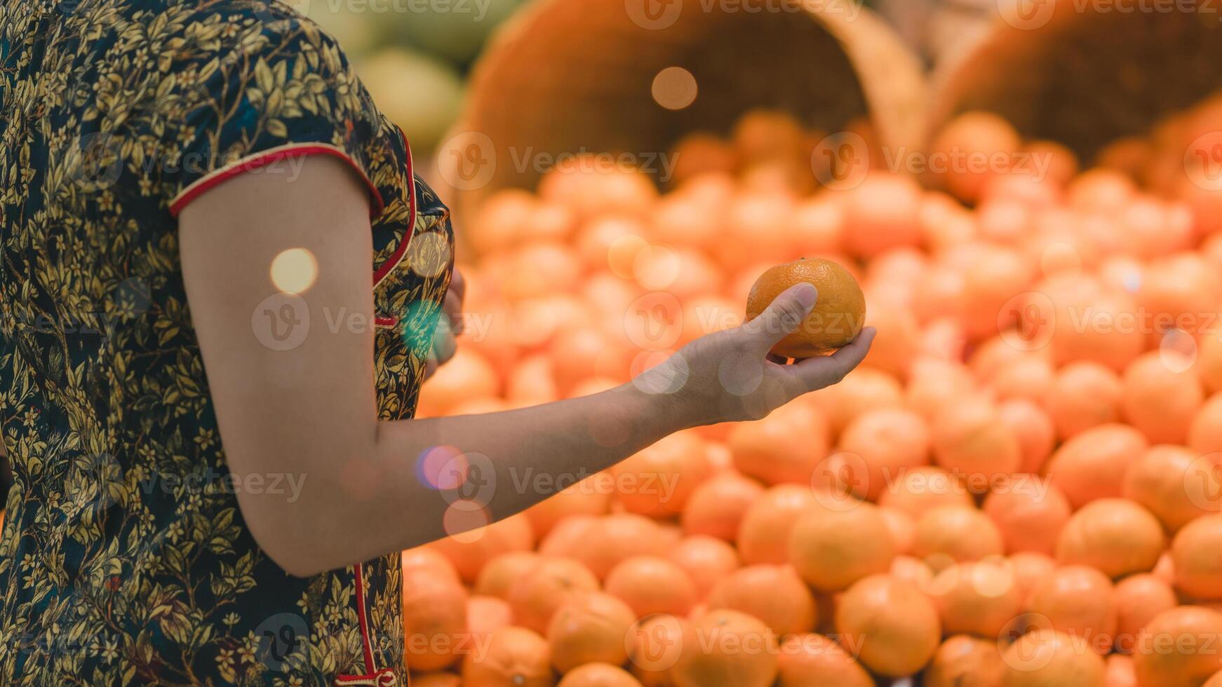 Shopper admires vibrant orange amidst display of citrus fruits, highlighting beauty of fresh produce and joy of selecting healthy, flavorful options photo