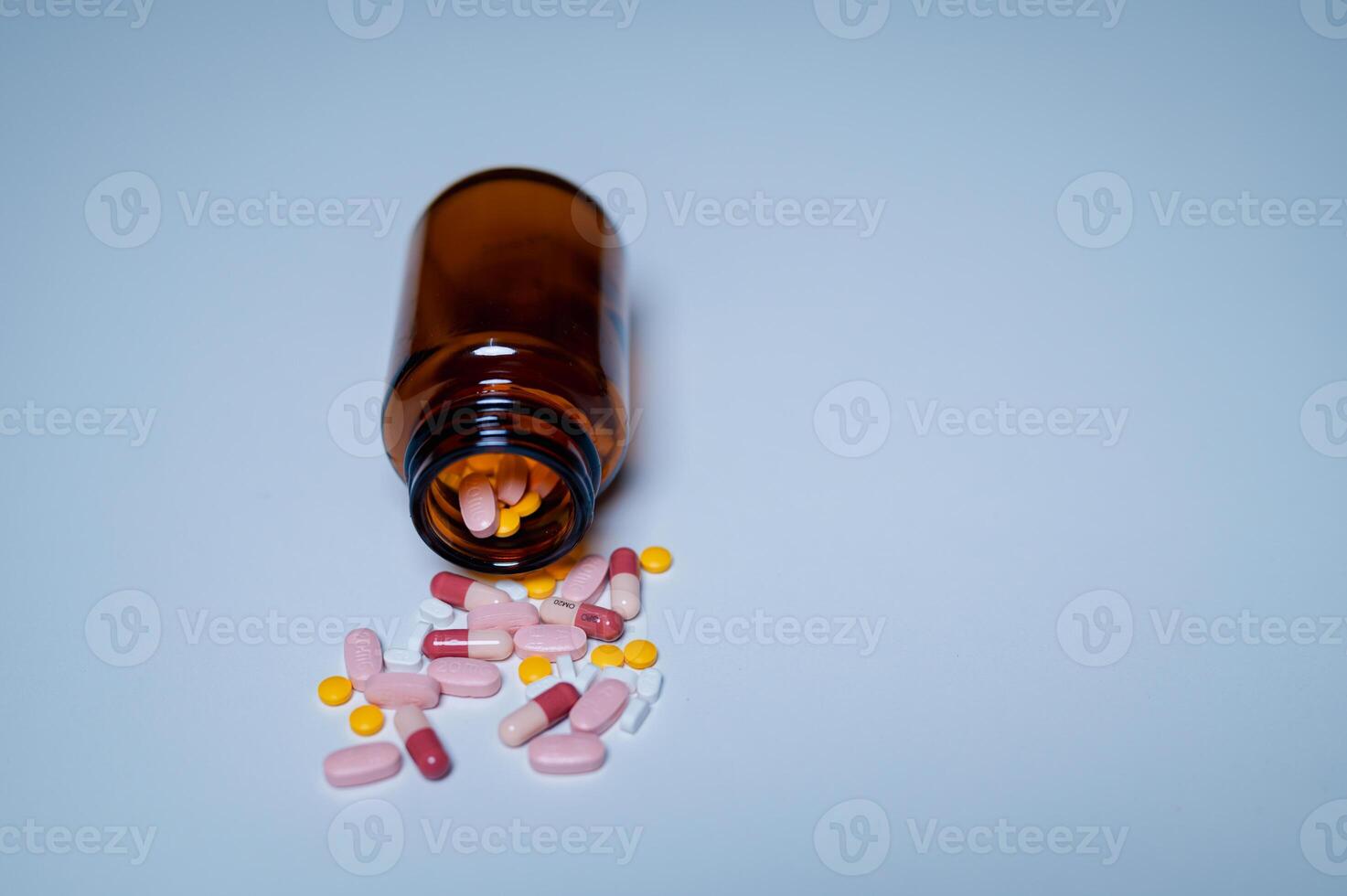 An array of colorful medication capsules and pills spills from an amber glass bottle, highlighting importance of pharmaceutical safety and responsible medication storage photo