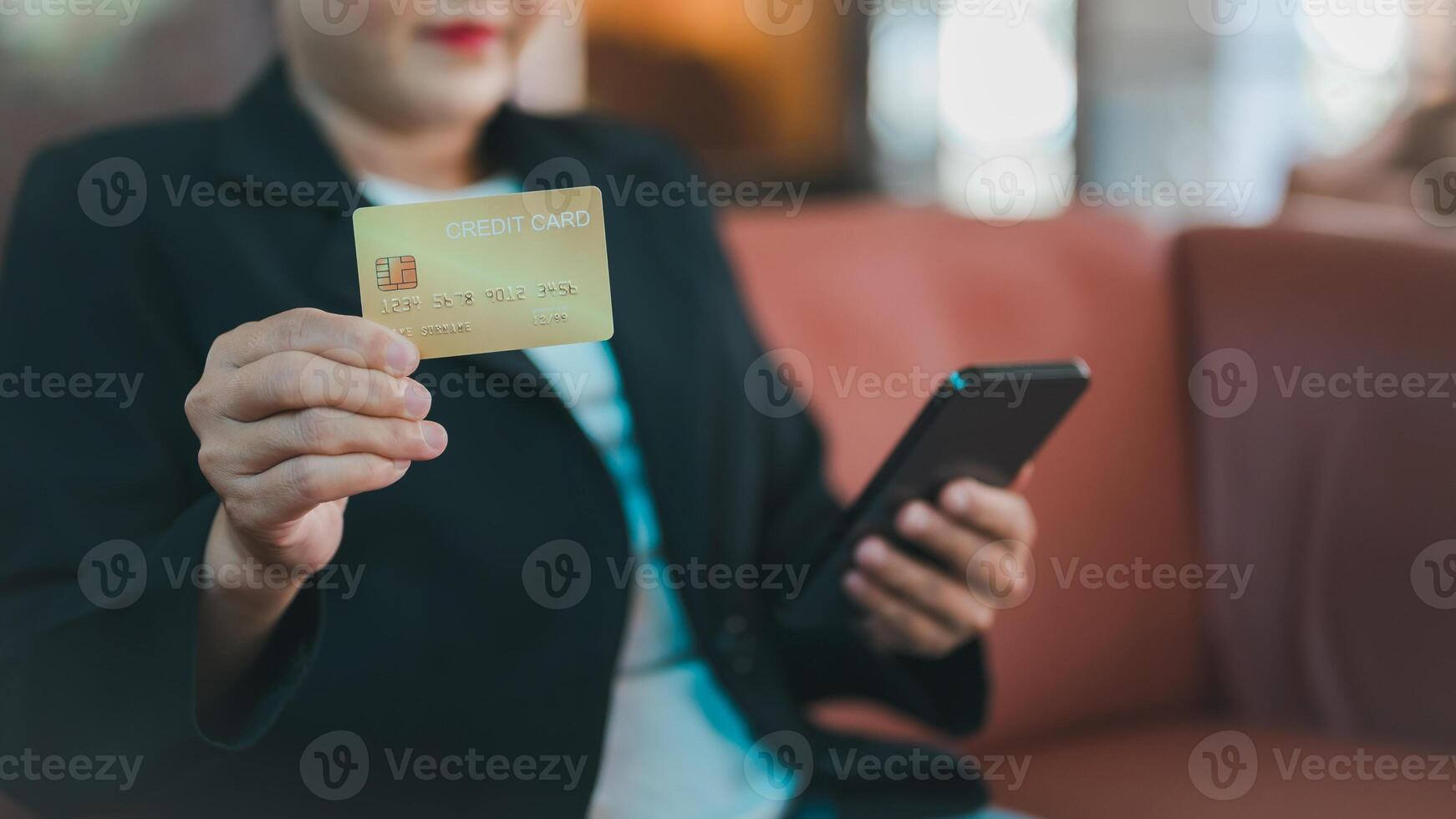 Business professional holding credit card in one hand while using smartphone in other, convenience of digital payments in todays financial landscape photo