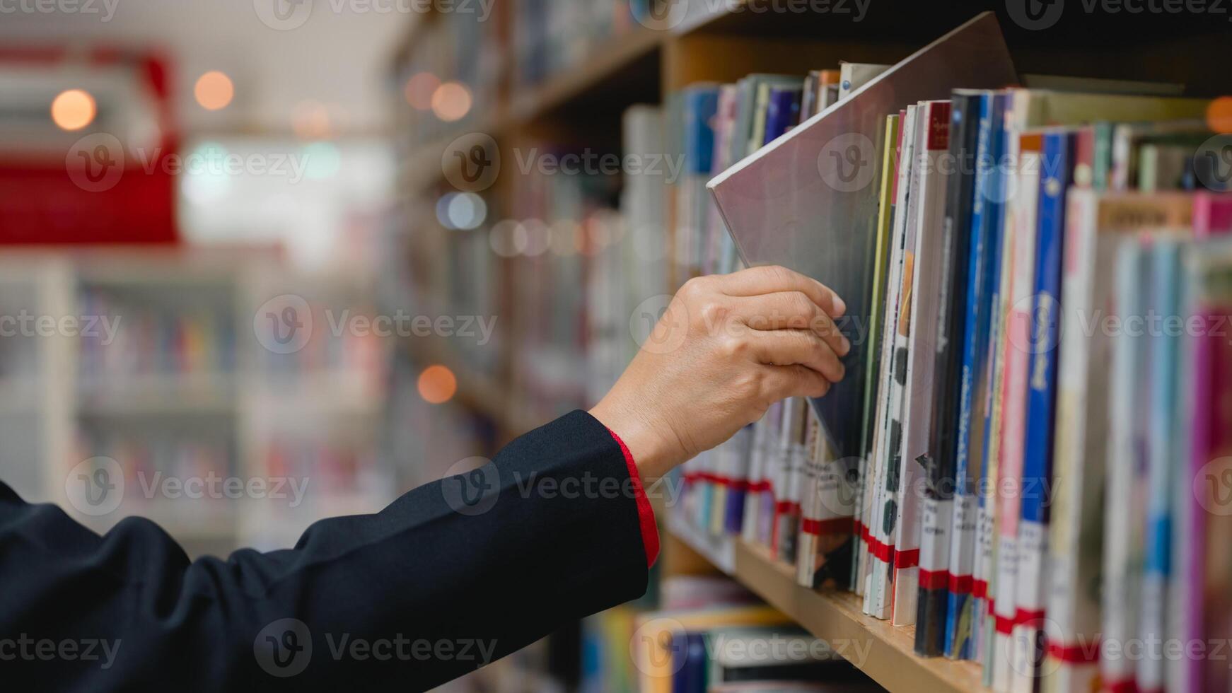 Youth learning concept. Hand reaches for book on library shelf, moment of exploration and discovery in world filled with knowledge and literature photo