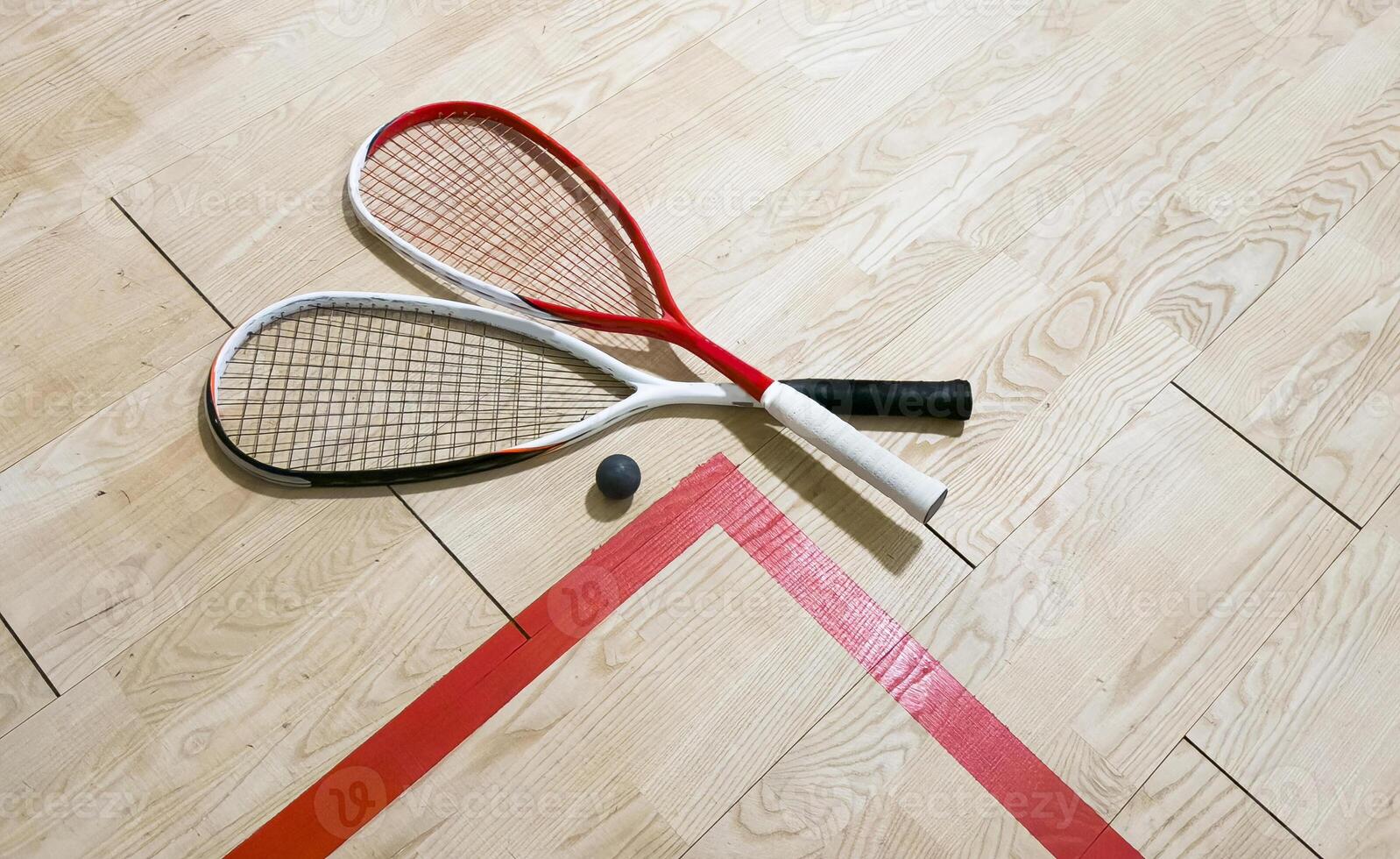 Squash rackets and ball on court floor, top view photo