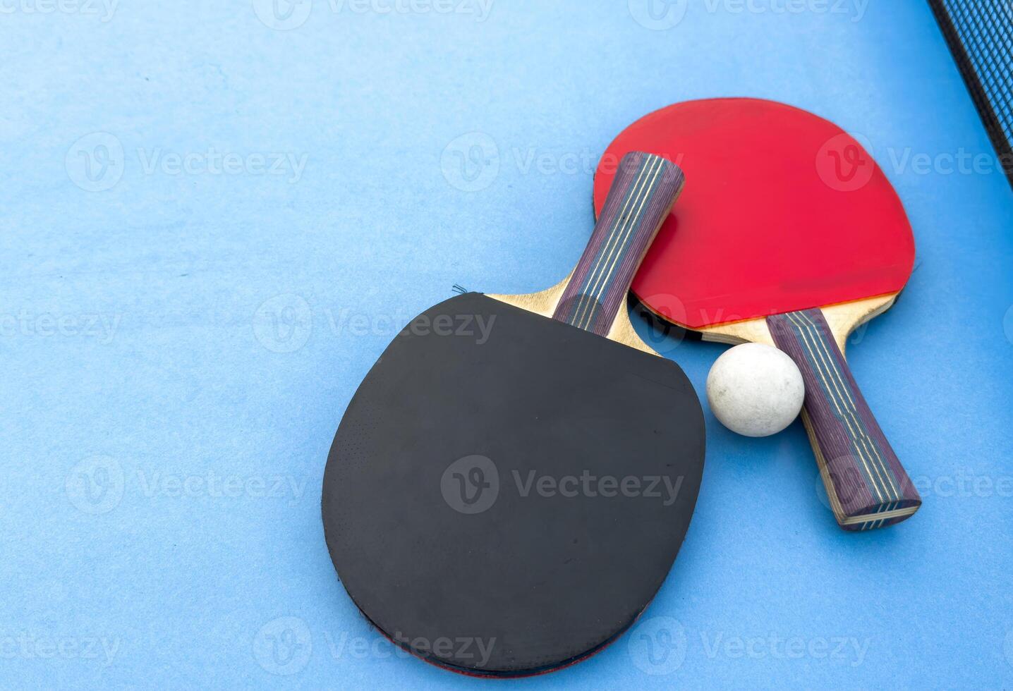 table tennis or ping pong racket and balls on a blue table photo