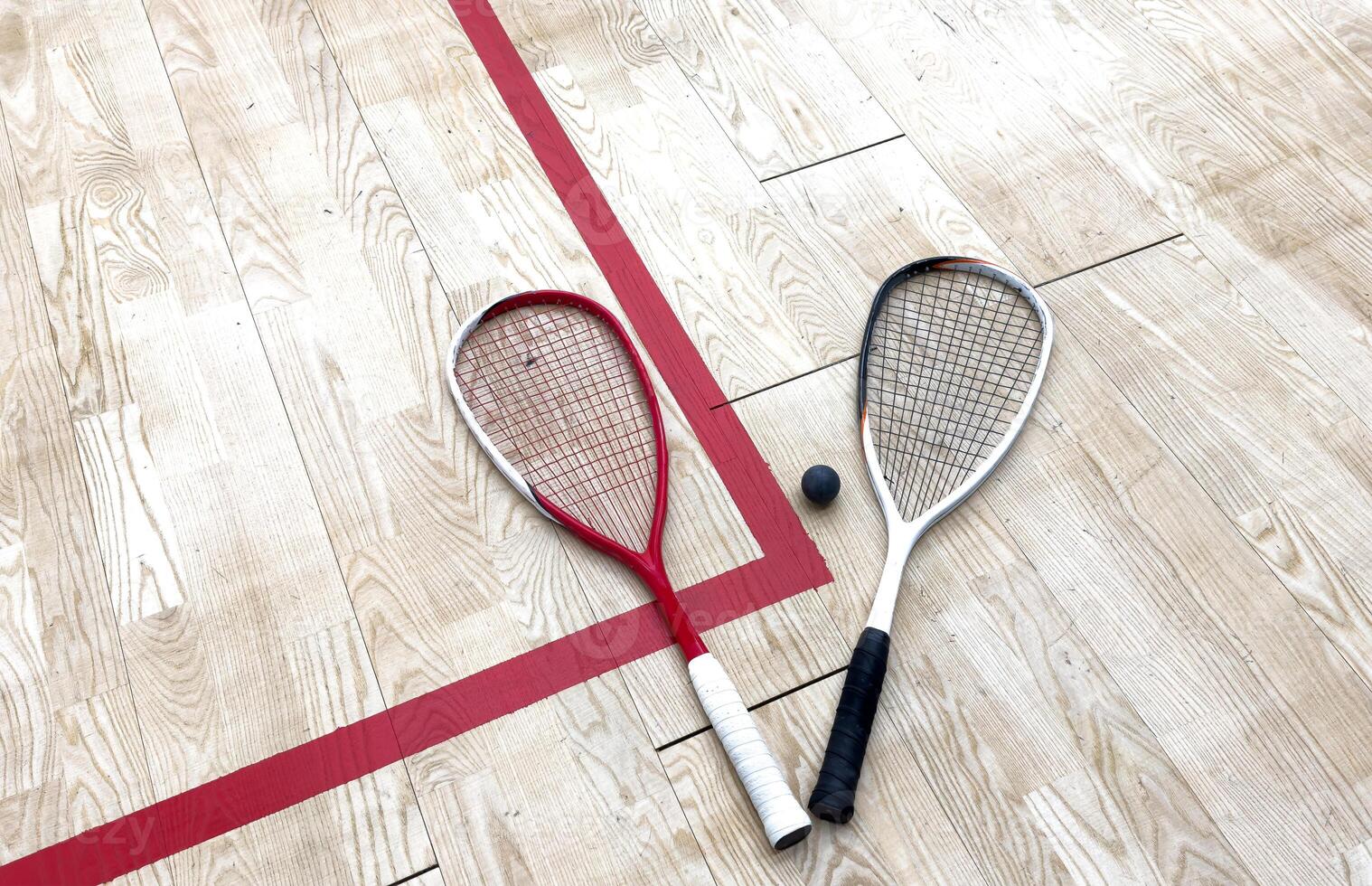 Squash Rackets And a Ball on a Wooden Court Floor. Sport Theme. photo