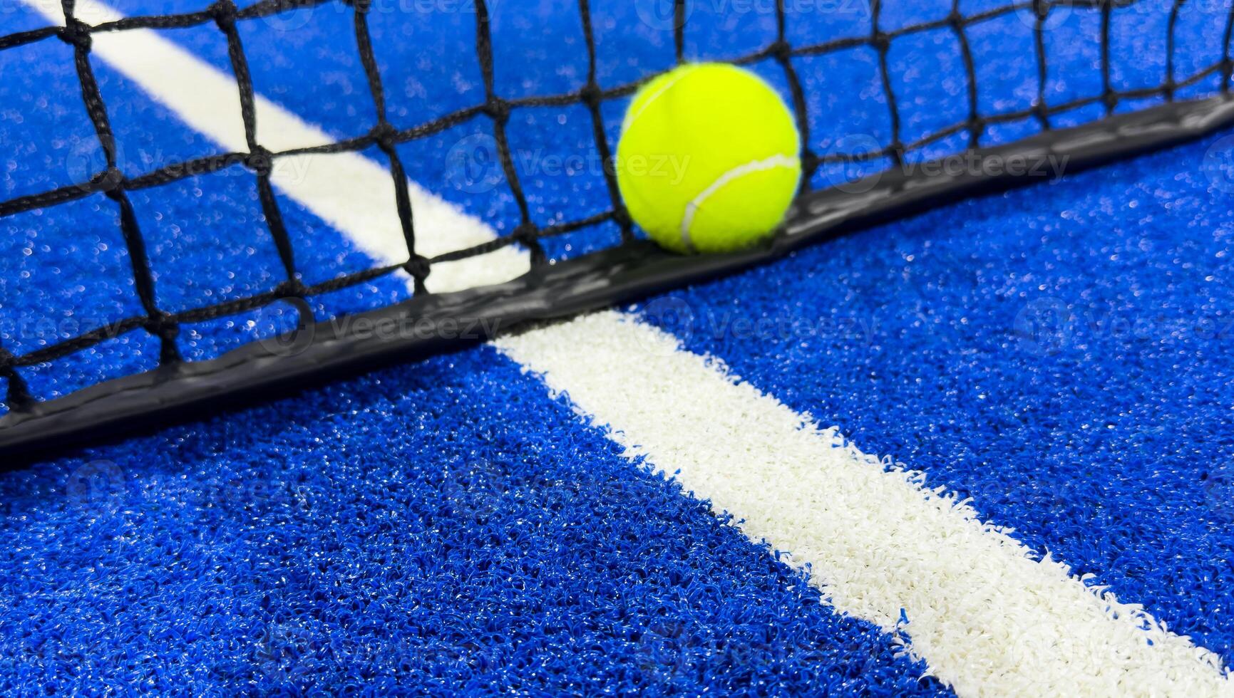 Ball of the net of a blue paddle tennis court. photo
