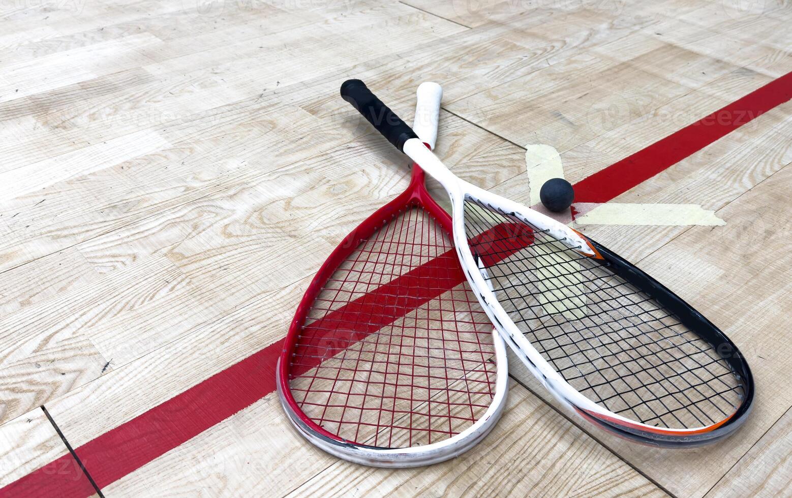 Squash Rackets And a Ball on a Wooden Court Floor. Sport Theme. photo