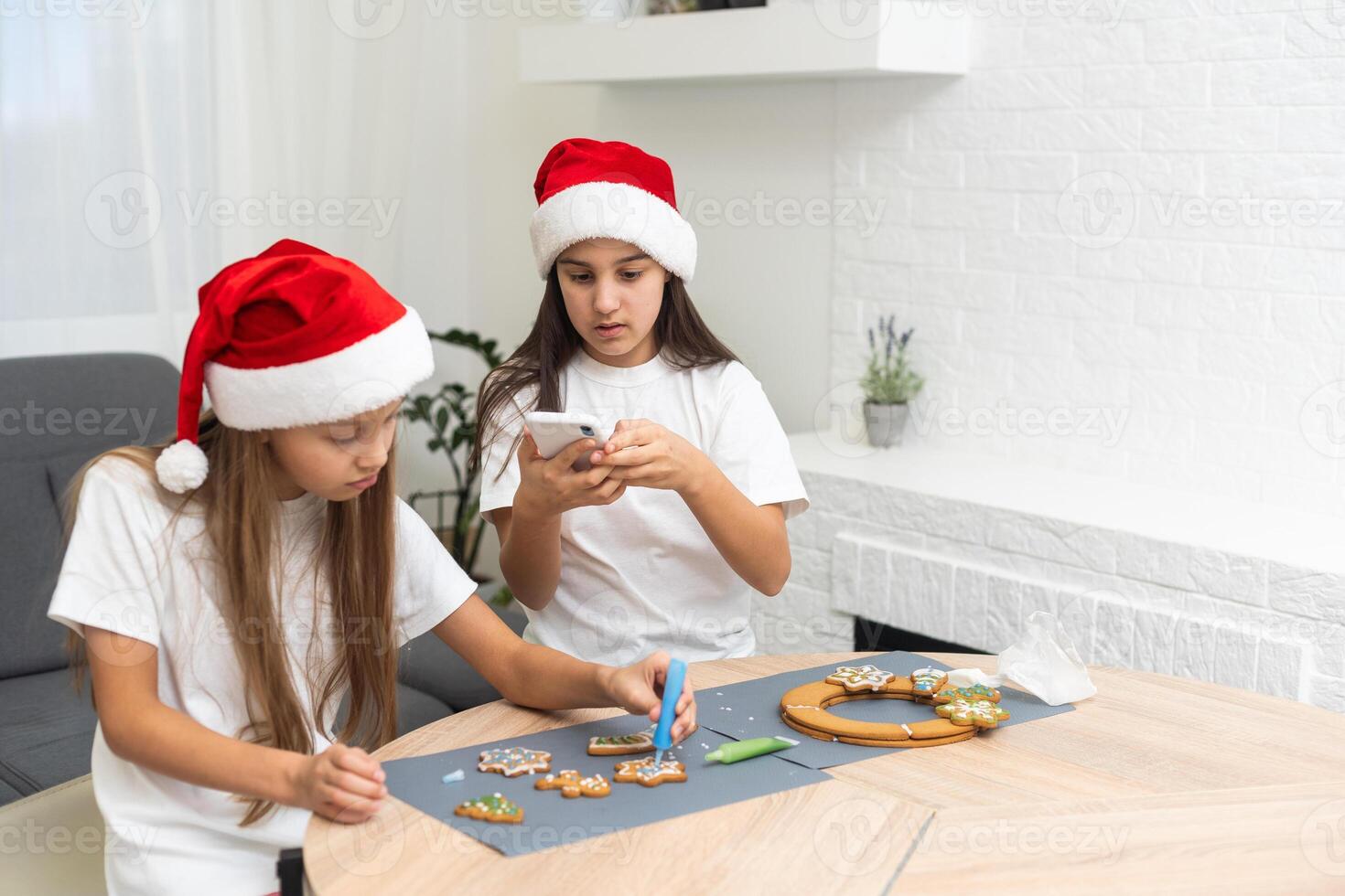 Two girls sisters are playing around in the kitchen after making Christmas cookies, they draw with flour on the table and on their faces. Christmas, New Year concept photo