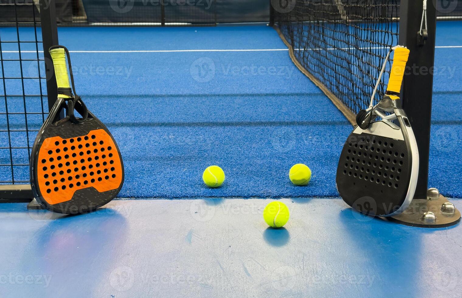 Black professional paddle tennis racket and ball with natural lighting on blue background. Horizontal sport theme poster, greeting cards, headers, website and app photo