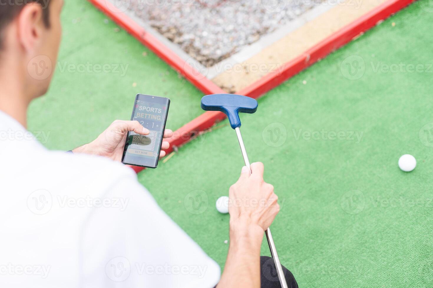 Touch screen in hand, tablet on golf club. smartphone with a sports betting application photo