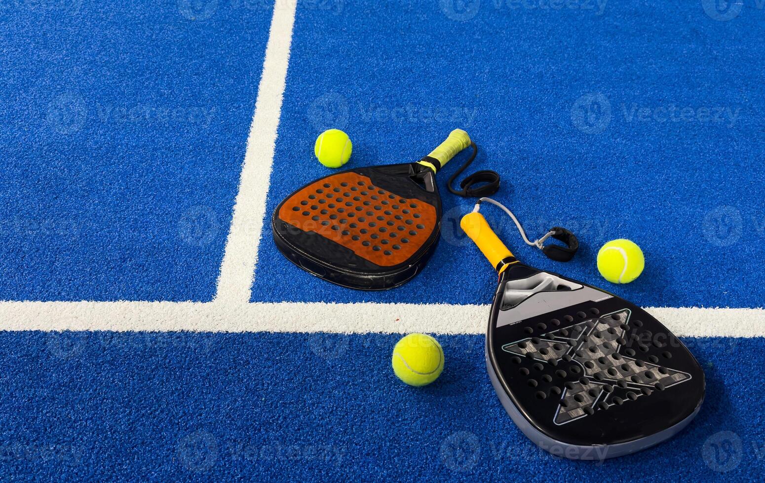Black professional paddle tennis racket and ball with natural lighting on blue background. Horizontal sport theme poster, greeting cards, headers, website and app photo