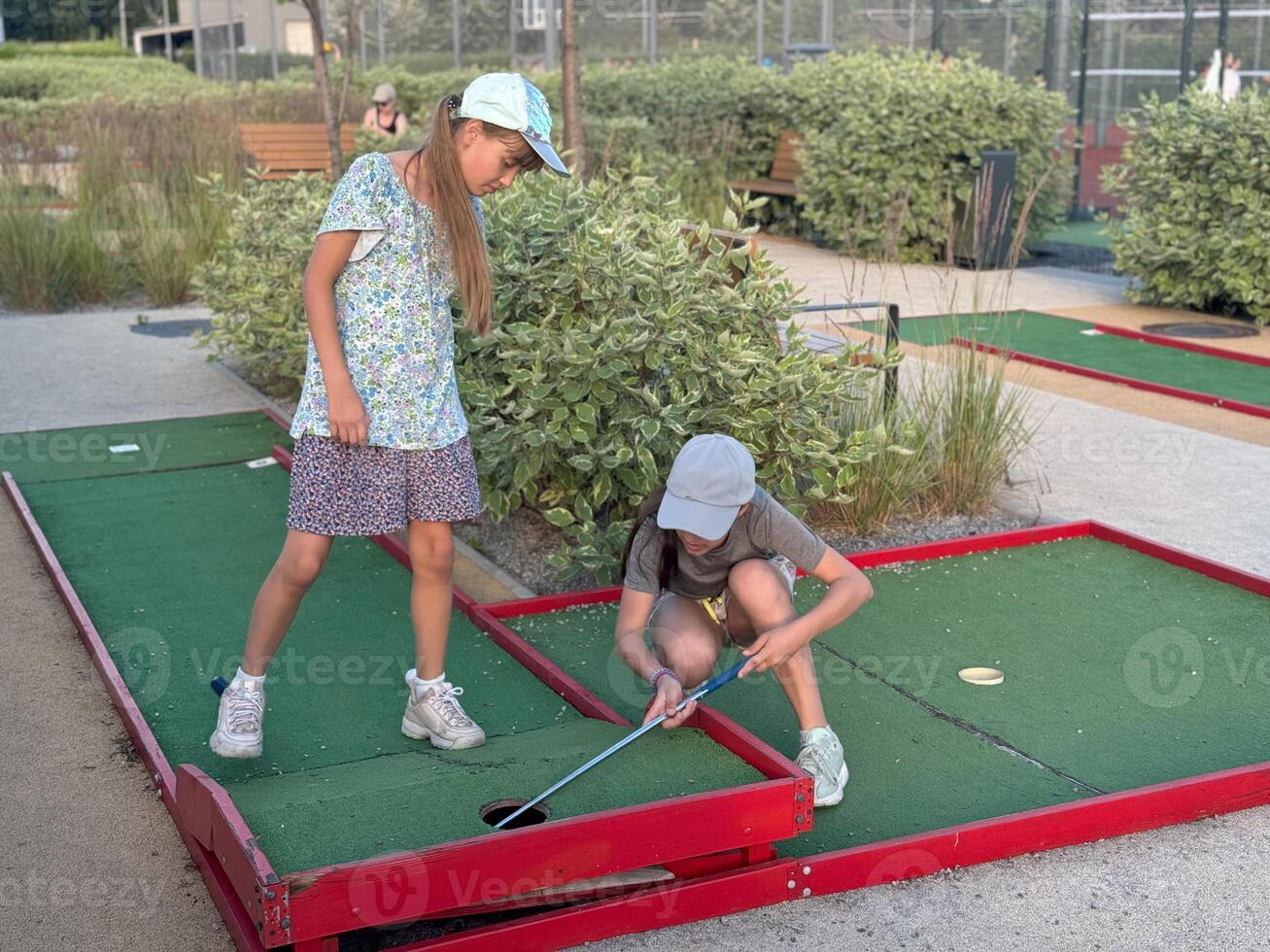 teenage girls play mini golf photo