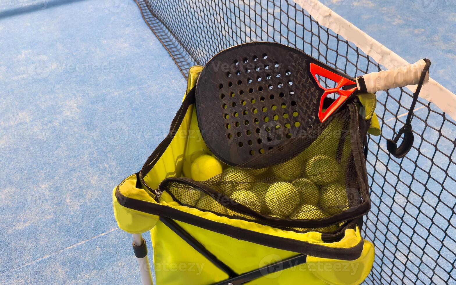 Paddle tennis racket, basket and balls in court image photo