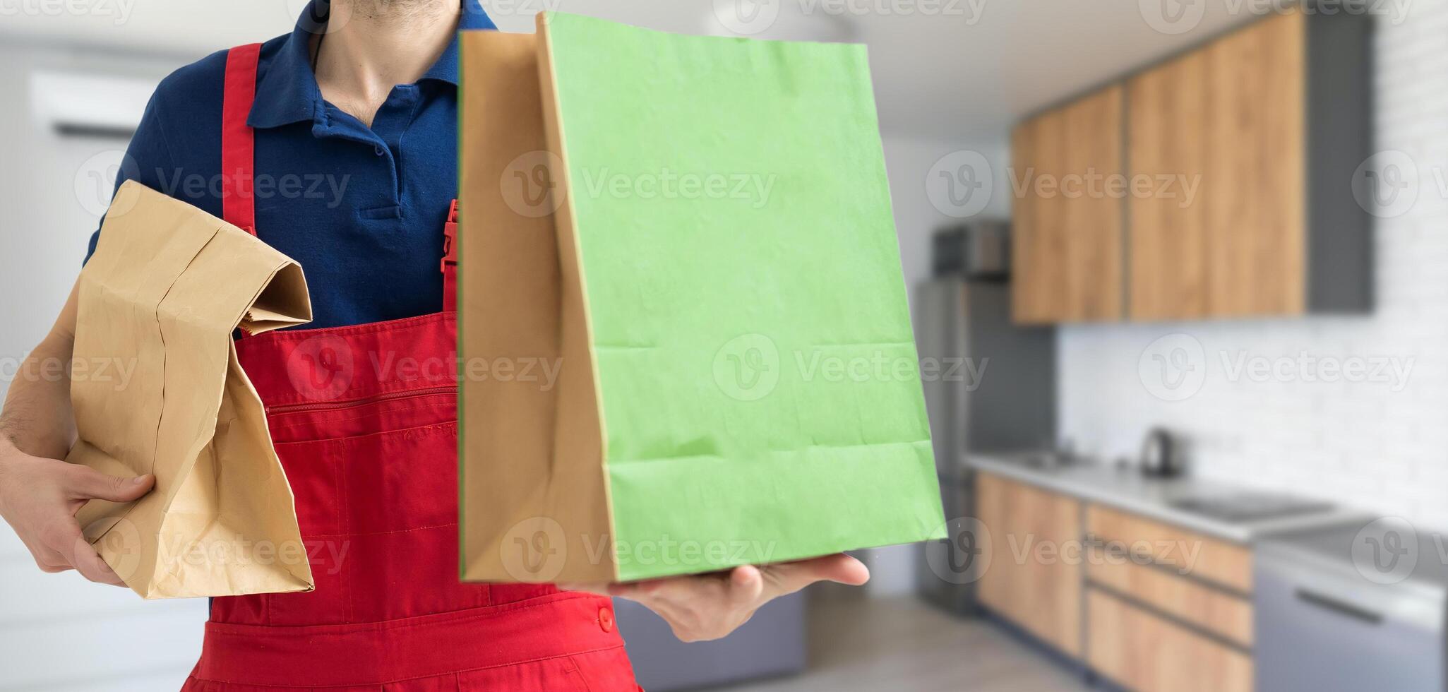 box with fast food being carried by delivery man in uniform for one of clients photo