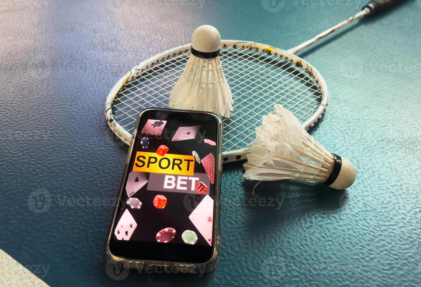 a badminton racket and a smartphone with sports bets photo