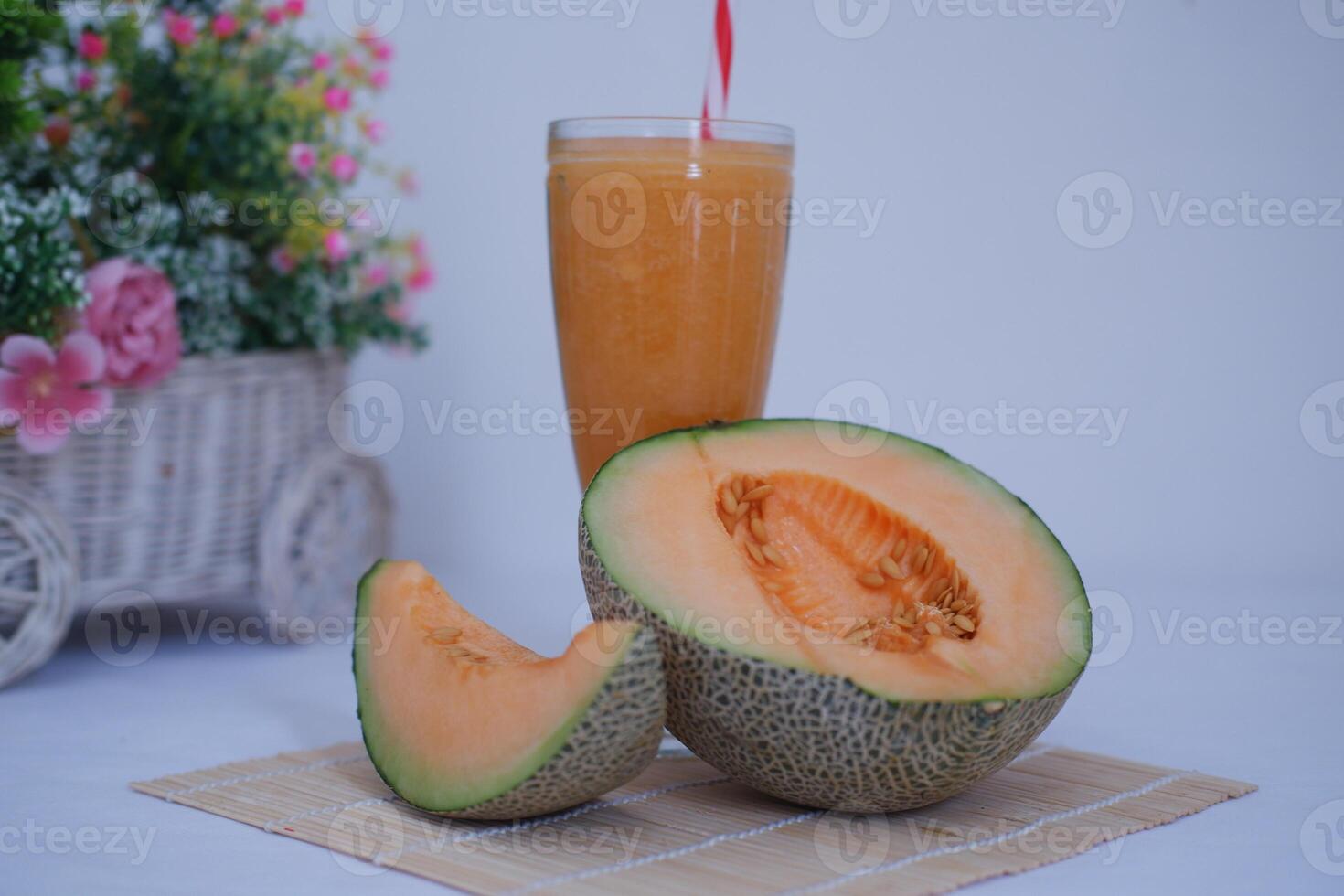 Melon juice in a glass and fresh melon on the table photo