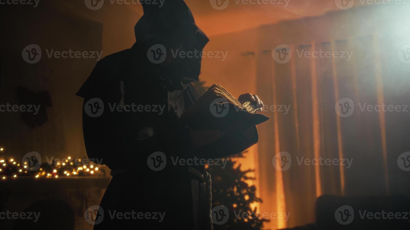 Silhouette Religious Monk Reads Bible Book In Front Of Christmas Tree At Night photo