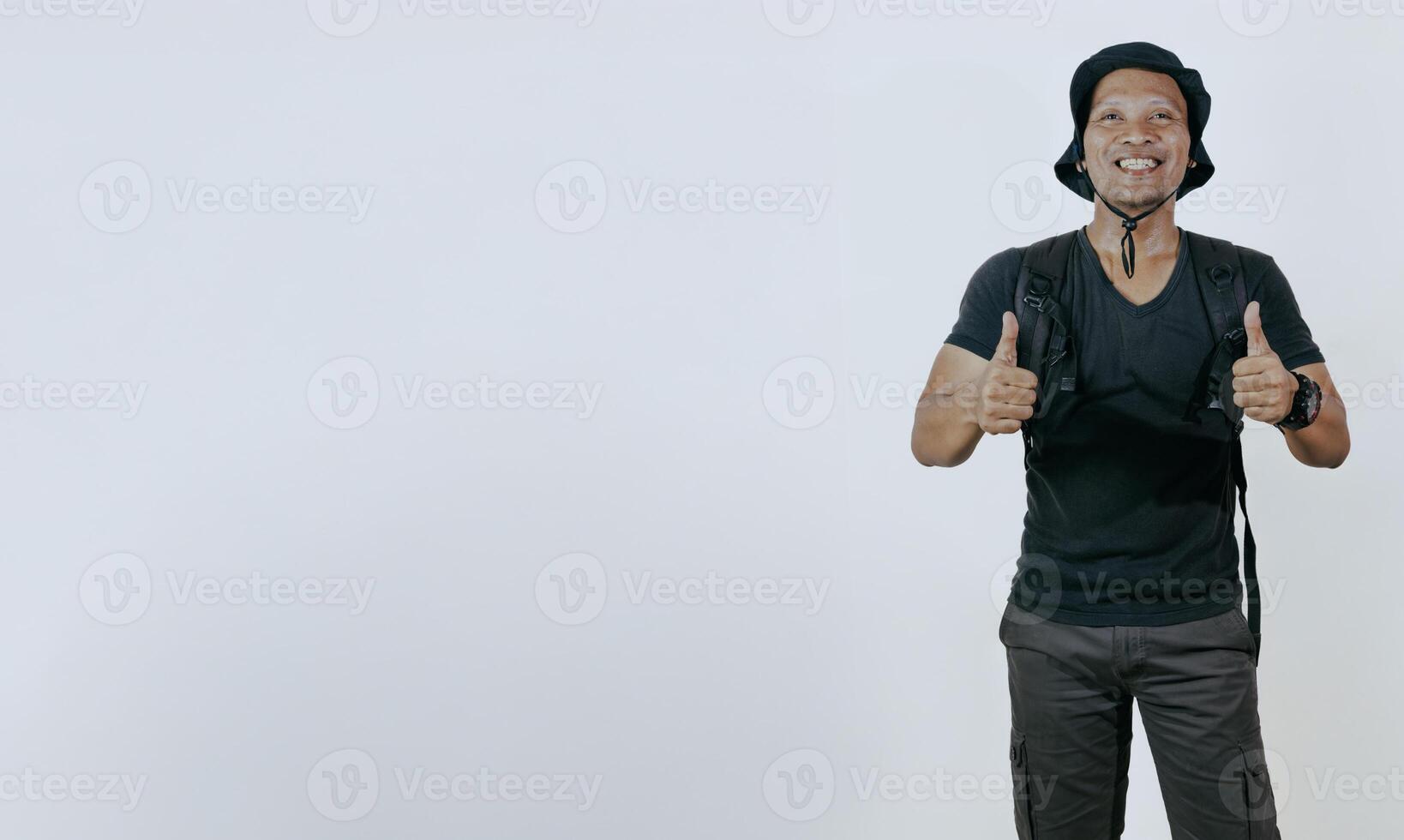 Excited young asian male tourist in sunglasses and backpack showing thumbs up isolated on white background and empty copy space for advertising. photo