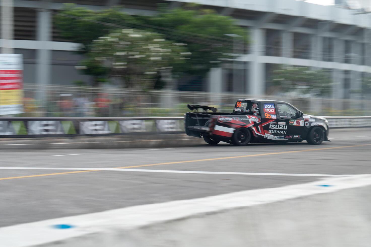 Songkhla, Moung, Thailand Oct 19, 2024 PT Maxnitron Motorsport, Stunning capture of racing Isuzu truck speeding around track, motion blur that highlights excitement and intensity of motorsport events photo