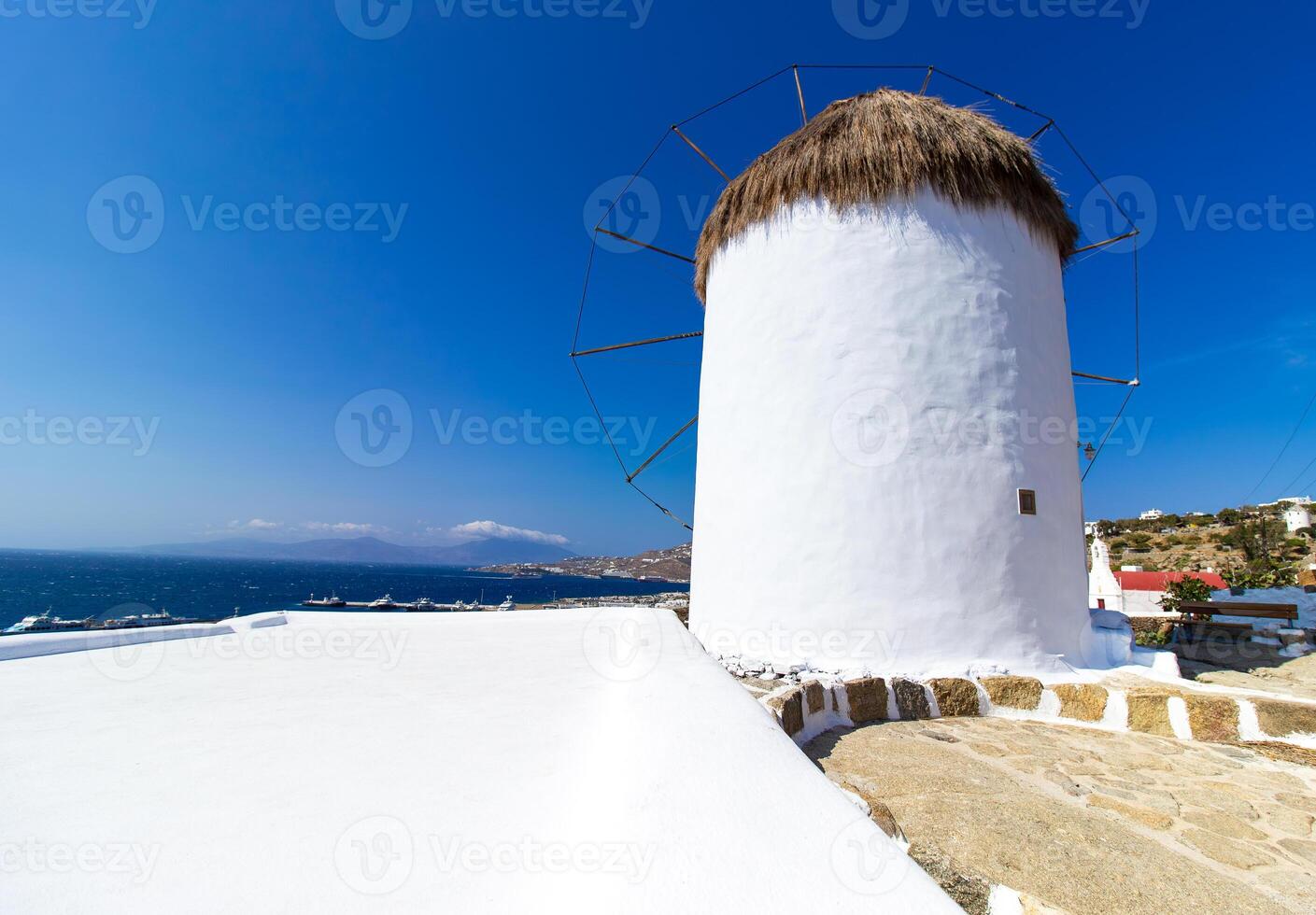 Traditional Greek windmills on Mykonos island under cloudy sky. Aerial view of iconic Mykonos windmills in Cyclades, Greece. photo