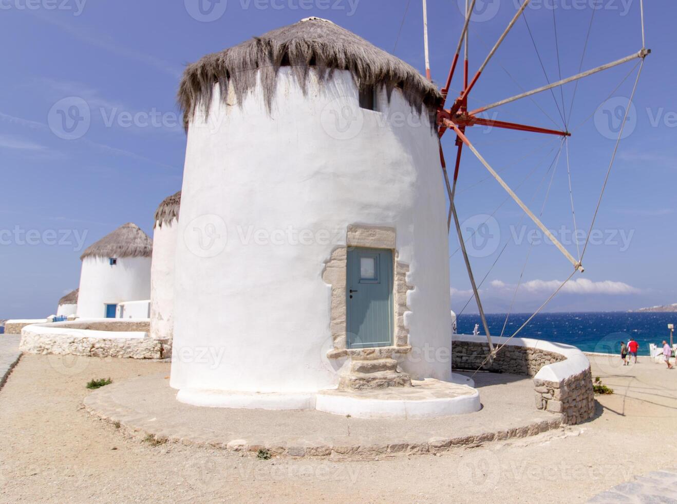 Traditional Greek windmills on Mykonos island under cloudy sky. Aerial view of iconic Mykonos windmills in Cyclades, Greece. photo