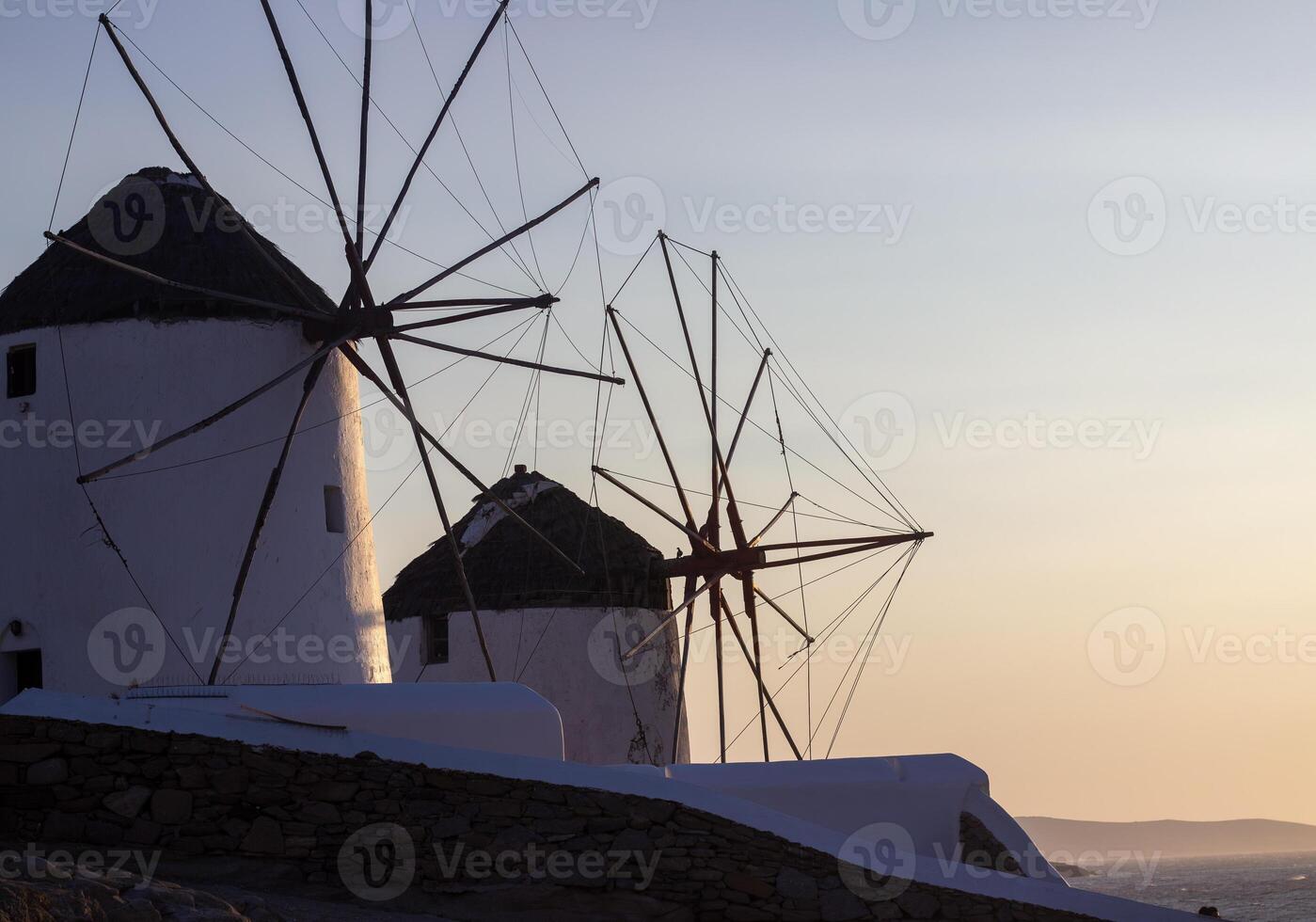Traditional Greek windmills on Mykonos island under cloudy sky. Aerial view of iconic Mykonos windmills in Cyclades, Greece. photo