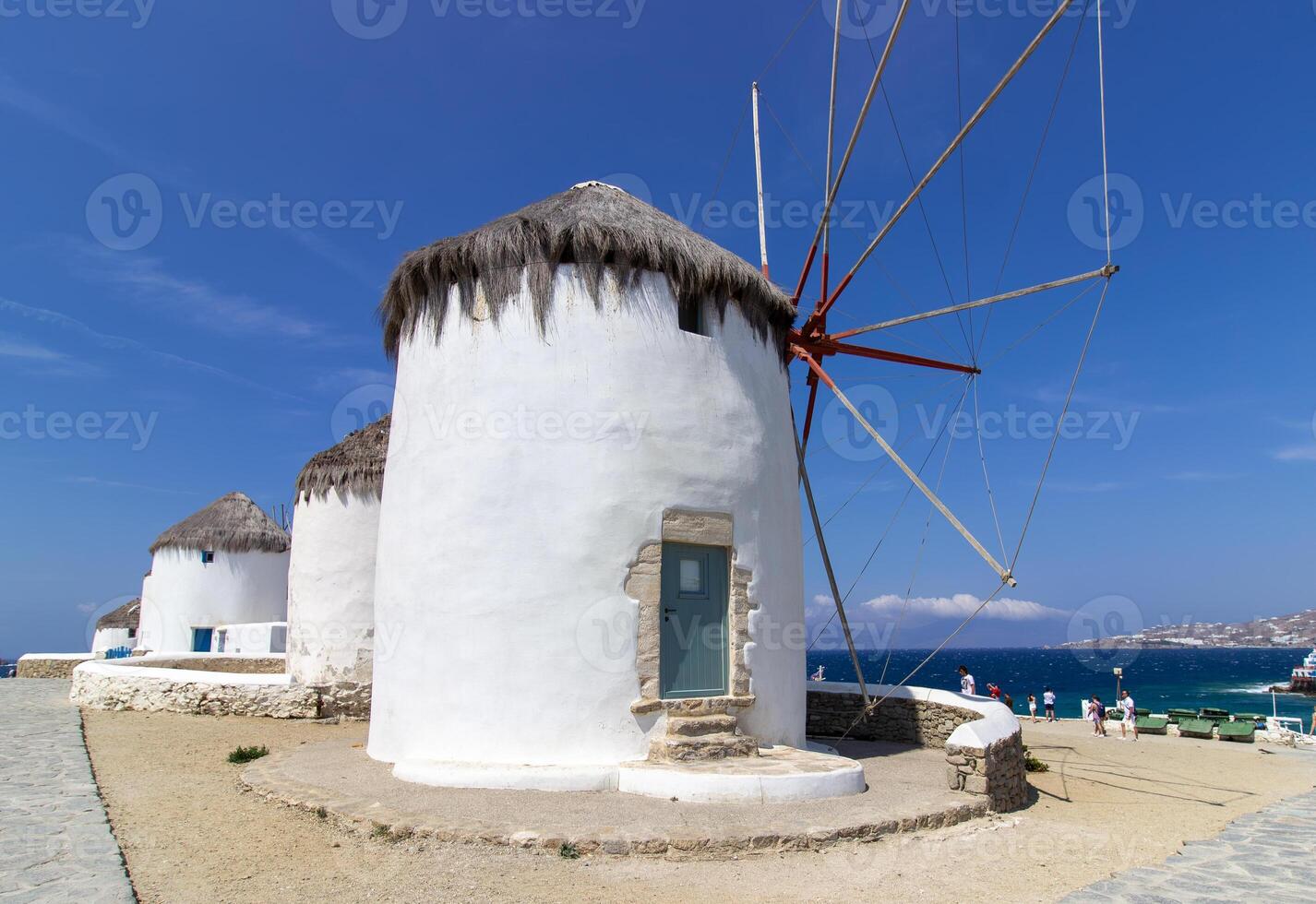 Traditional Greek windmills on Mykonos island under cloudy sky. Aerial view of iconic Mykonos windmills in Cyclades, Greece. photo