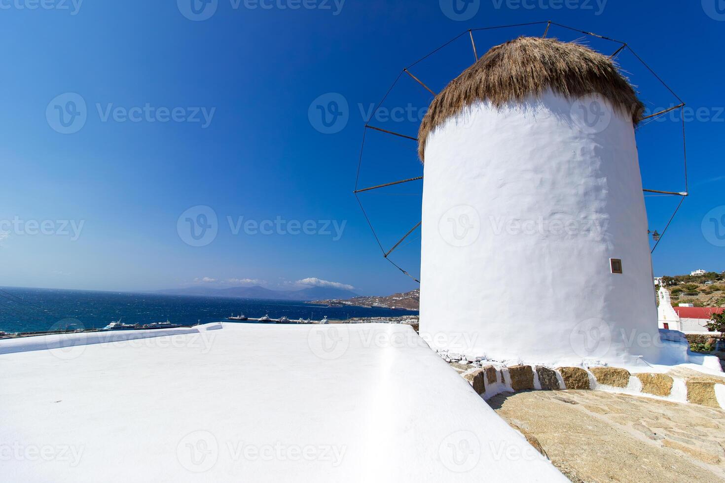 Traditional Greek windmills on Mykonos island under cloudy sky. Aerial view of iconic Mykonos windmills in Cyclades, Greece. photo