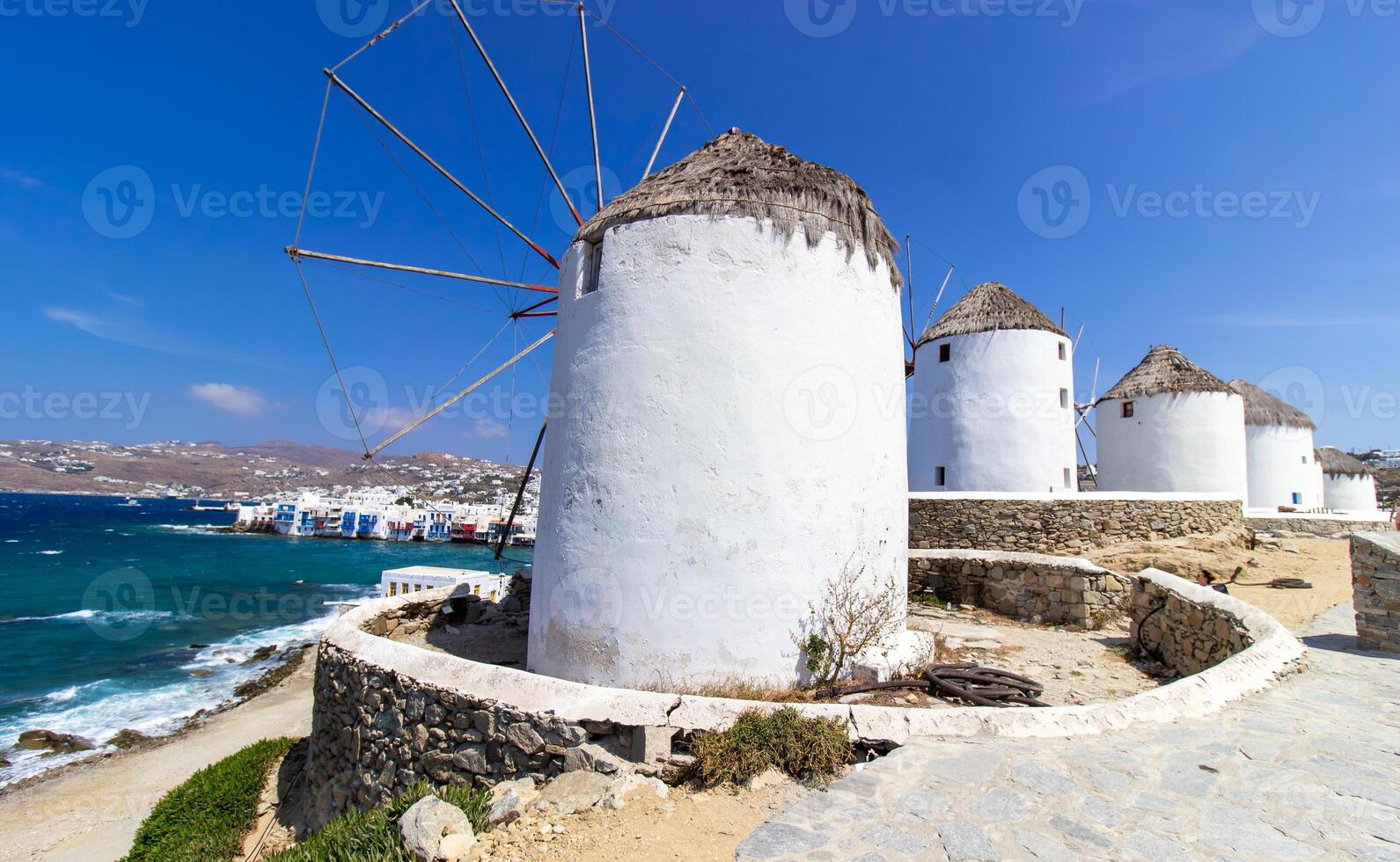 Traditional Greek windmills on Mykonos island under cloudy sky. Aerial view of iconic Mykonos windmills in Cyclades, Greece. photo