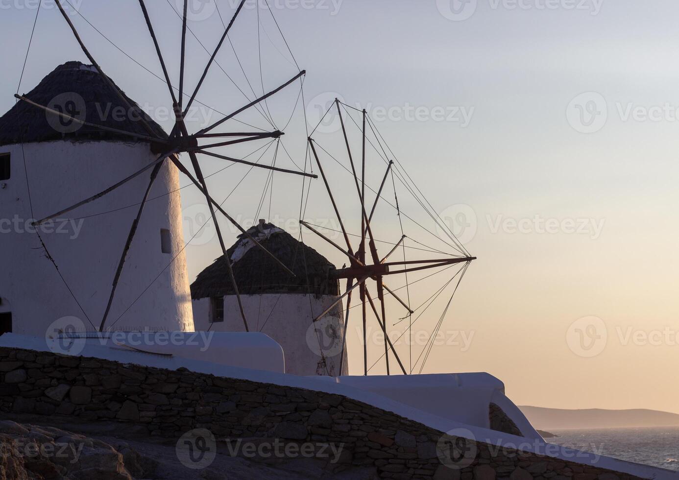 Traditional Greek windmills on Mykonos island under cloudy sky. Aerial view of iconic Mykonos windmills in Cyclades, Greece. photo