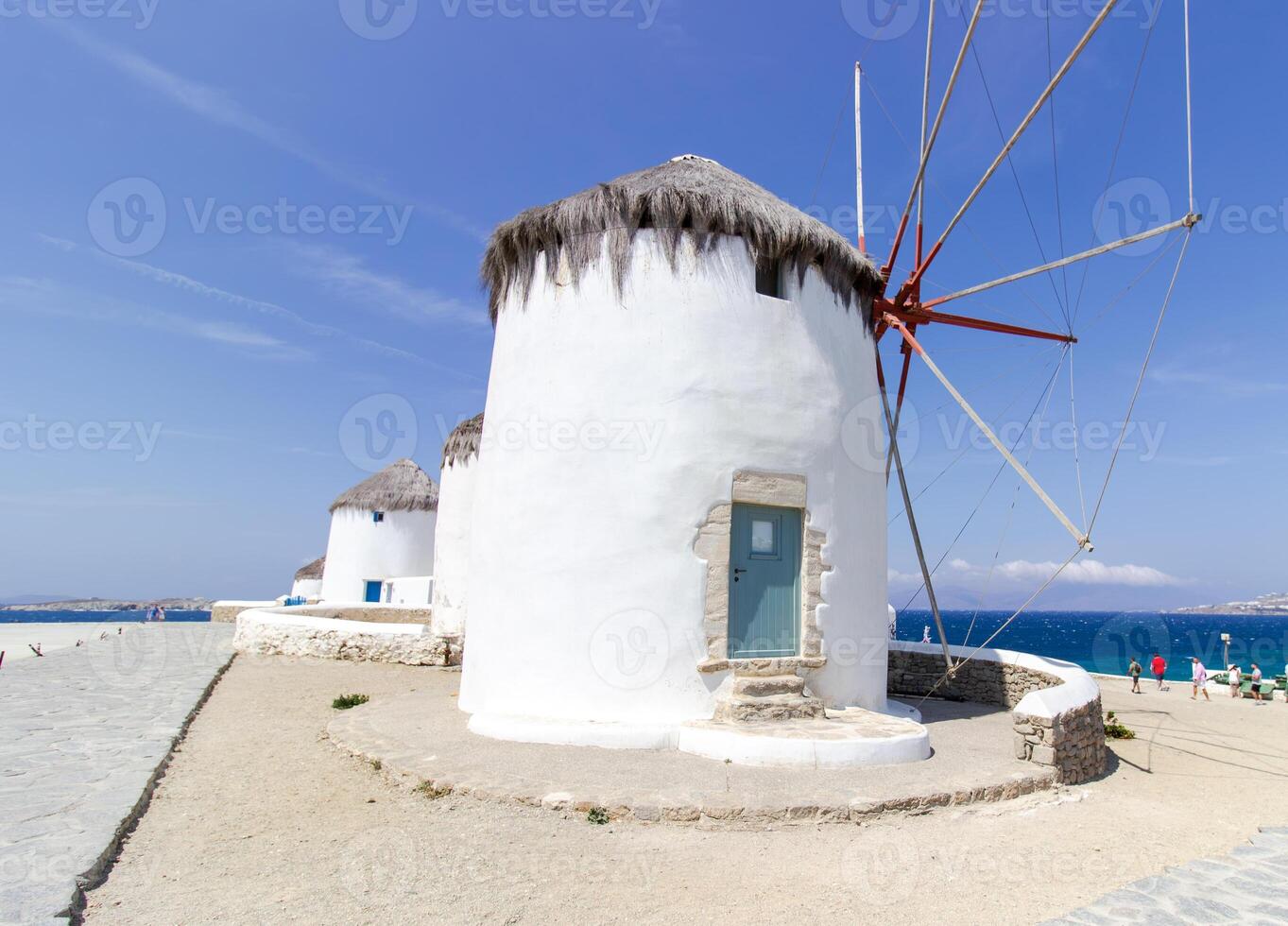 Traditional Greek windmills on Mykonos island under cloudy sky. Aerial view of iconic Mykonos windmills in Cyclades, Greece. photo