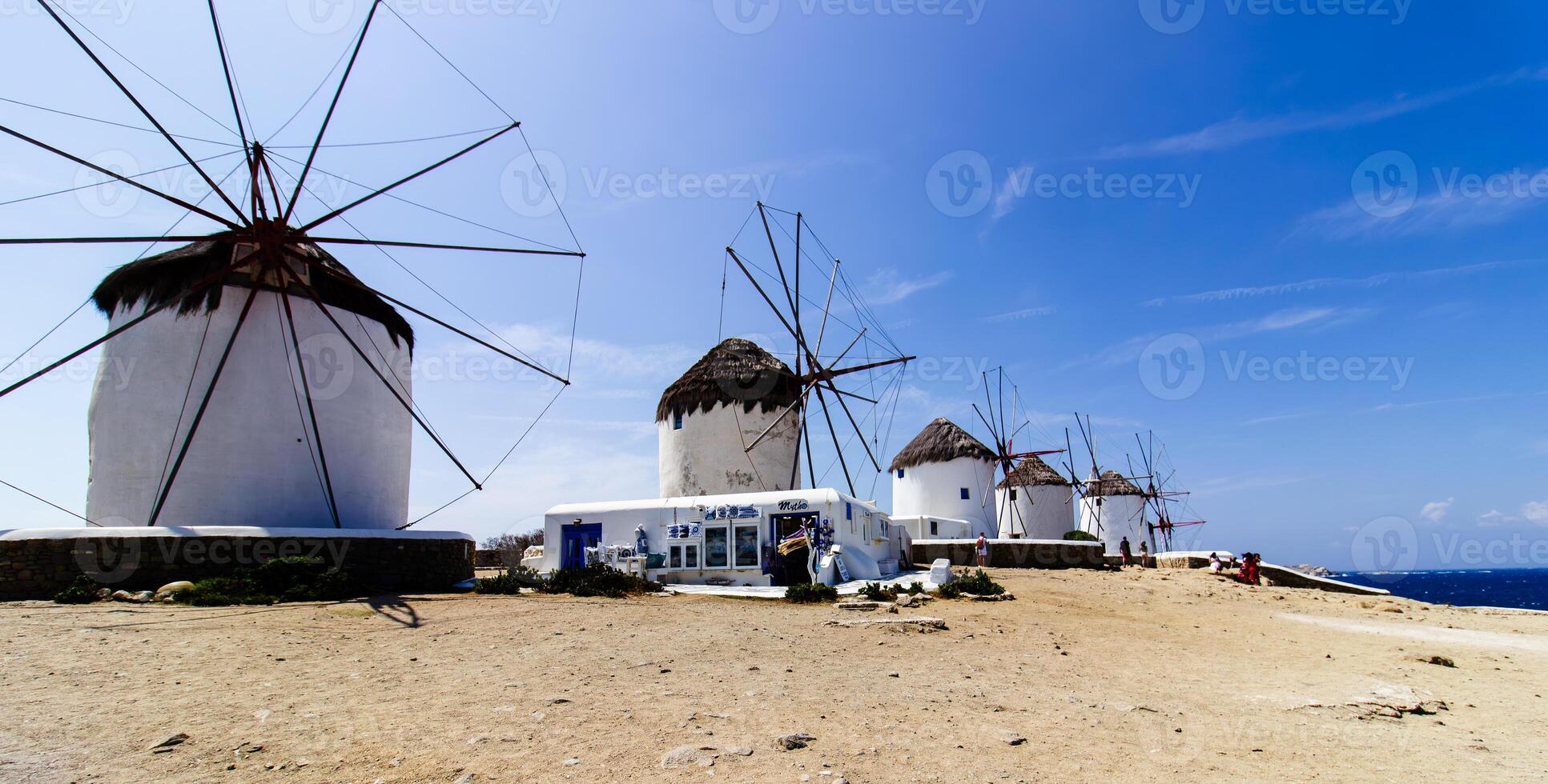 Traditional Greek windmills on Mykonos island under cloudy sky. Aerial view of iconic Mykonos windmills in Cyclades, Greece. photo